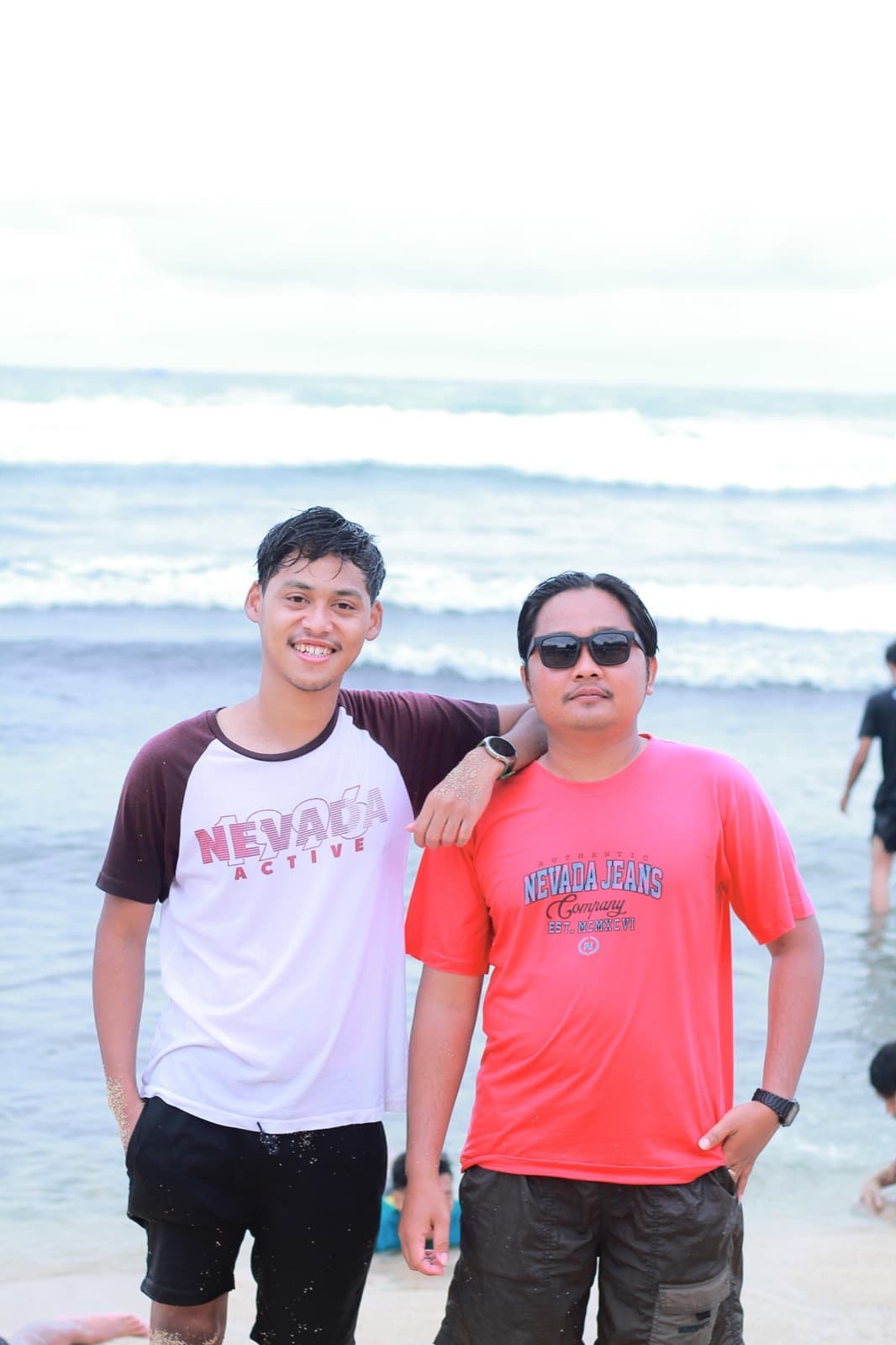 Dua anggota berfoto di tepi pantai