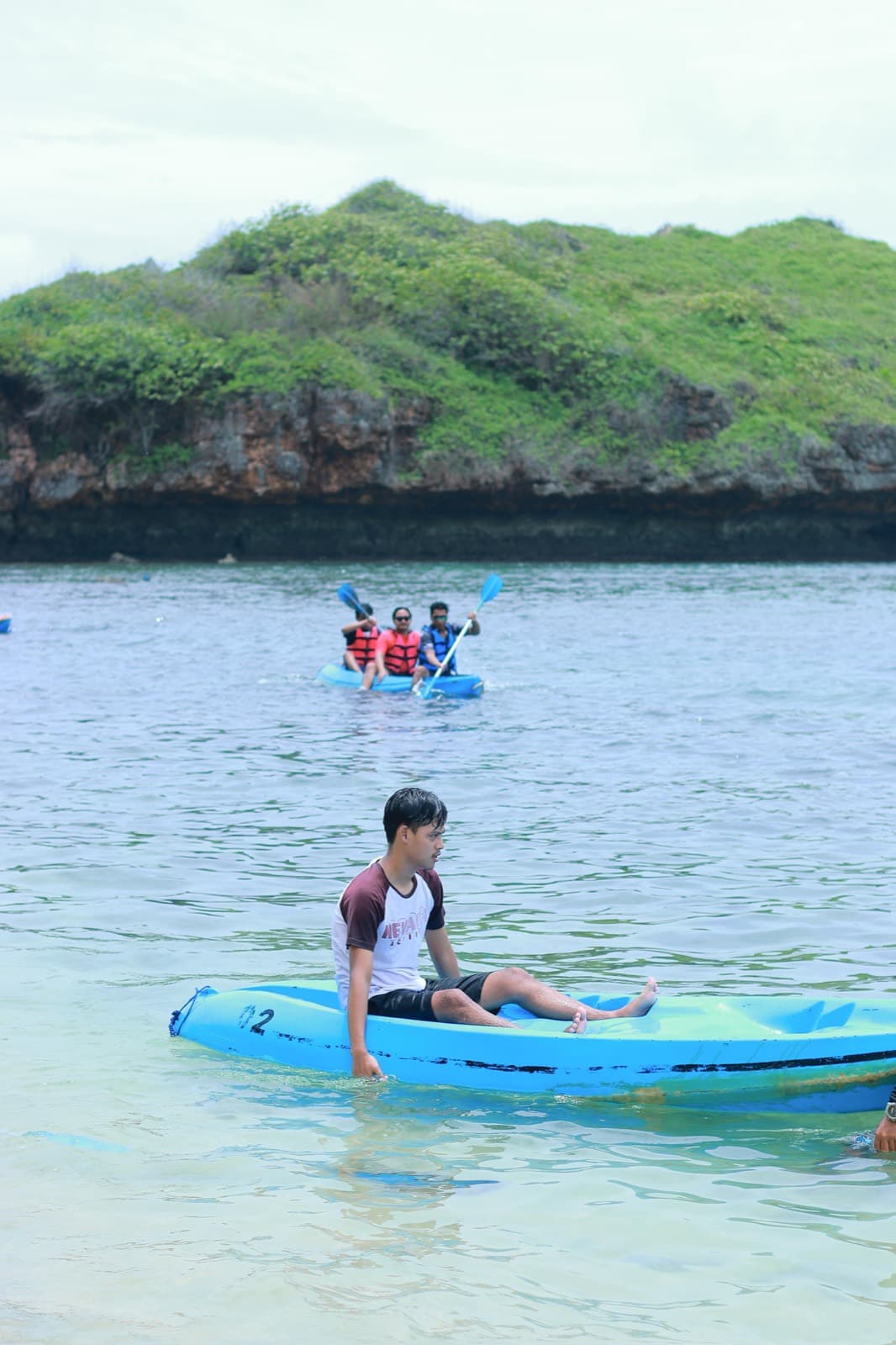 Naik kano di teluk berbukit hijau